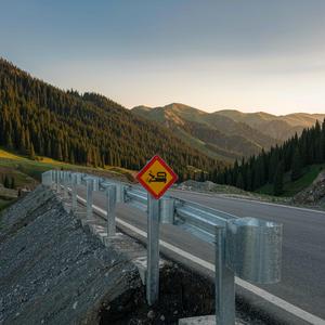 New highway guardrail along a mountain road at golden hour