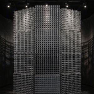 Tower of galvanized welded wire mesh panels under dramatic spotlight
