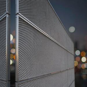 Stainless steel mesh architectural facade at dusk