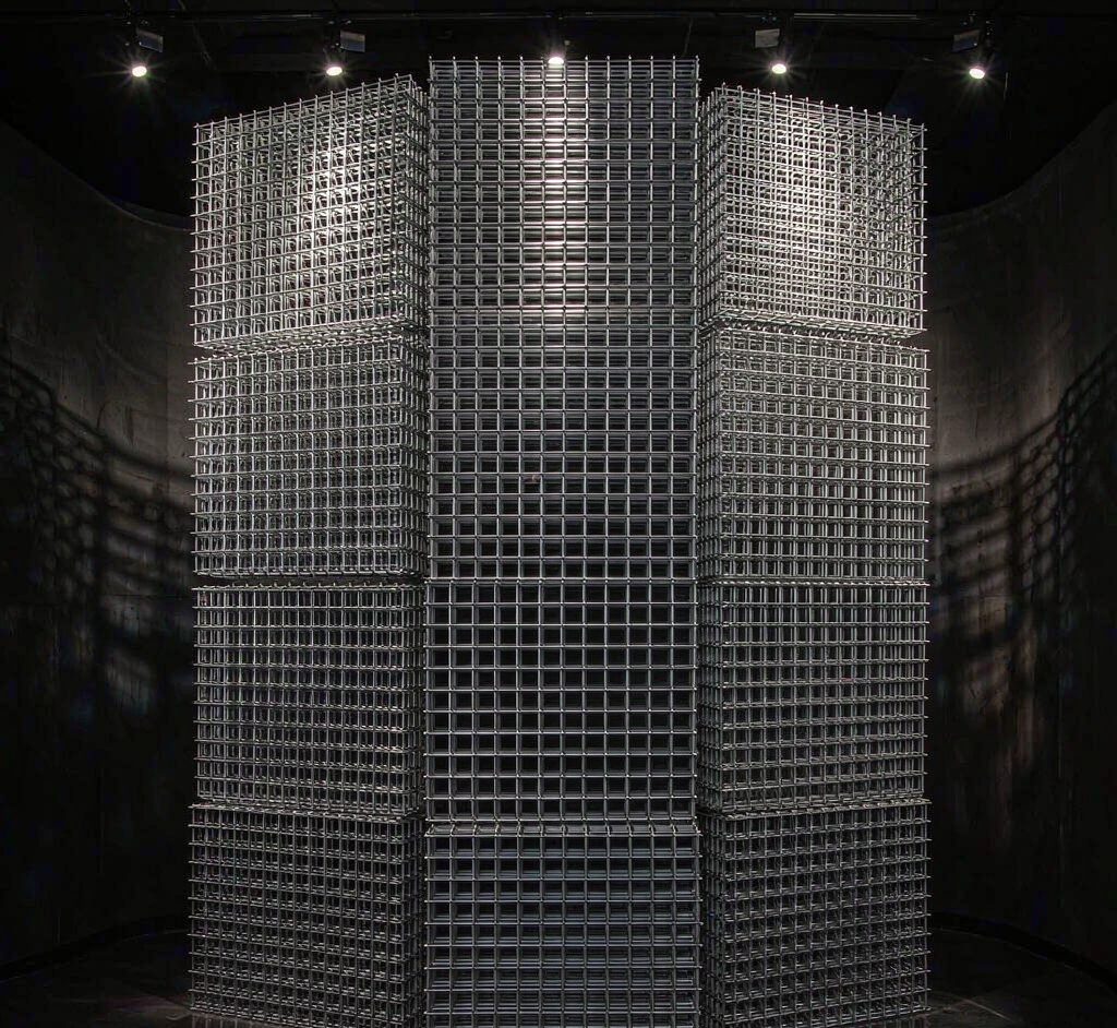 Tower of galvanized welded wire mesh panels under dramatic spotlight
